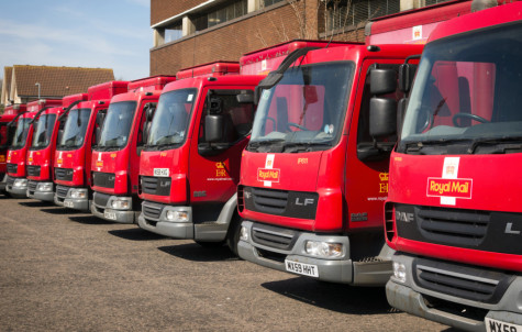 Ipswich, Suffolk, England - April 20, 2015: A row of Royal Mail vans parked outside an urban building in Ipswich, Suffolk, England. The Royal Mail uses trains, a ship and aircraft as well as vans of various sizes, push trolleys and bicycles, though these are being phased out.
